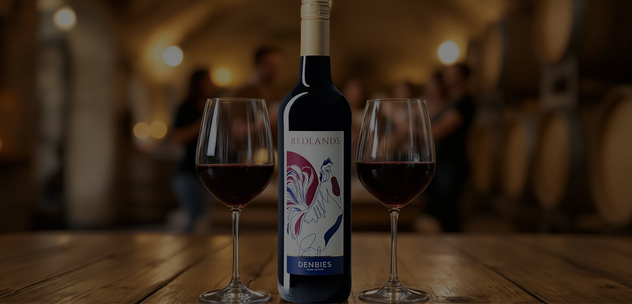 Wine bottle with two glasses of red wine in a cellar setting