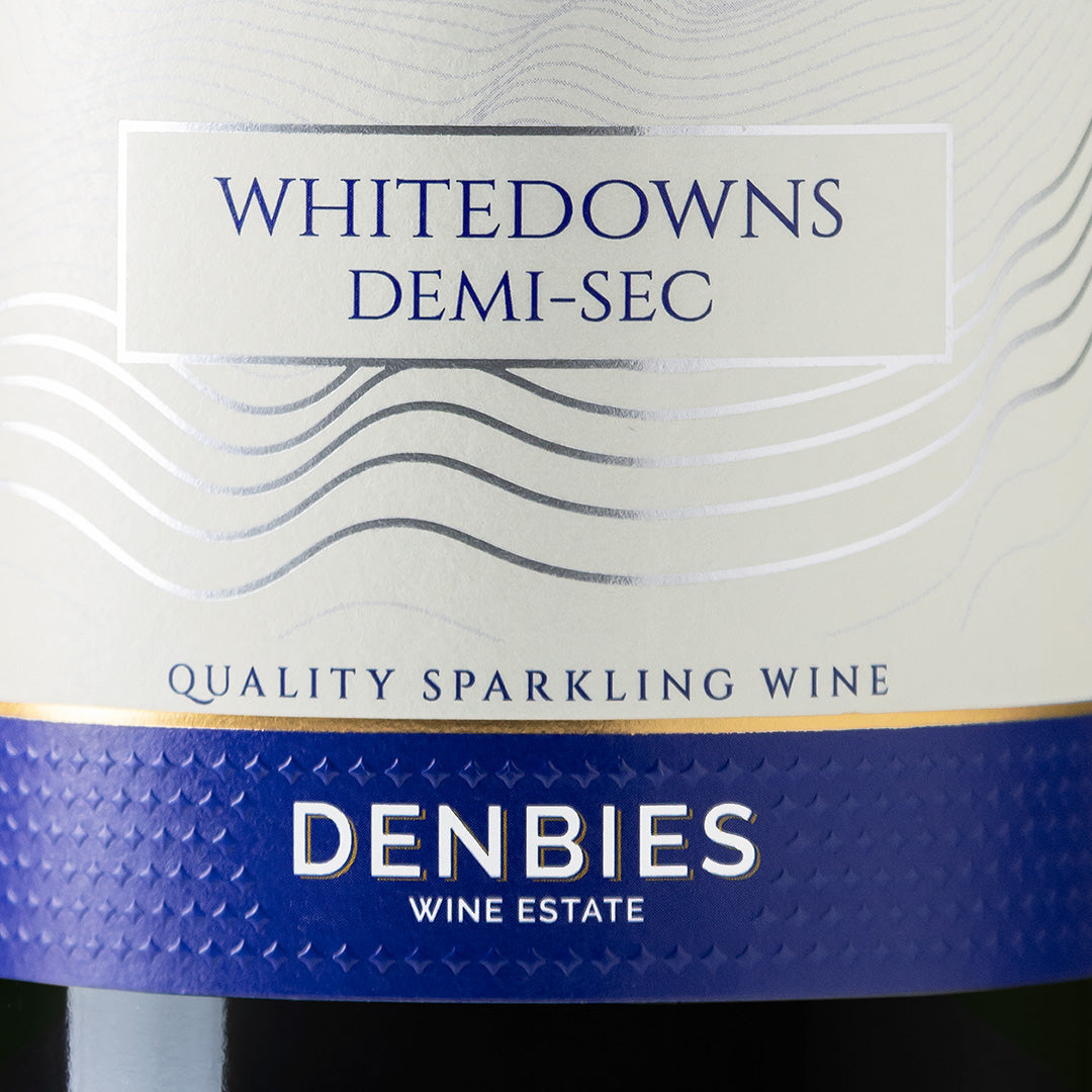 Close-up detail of the Demi-sec NV wine label showing the art and typography