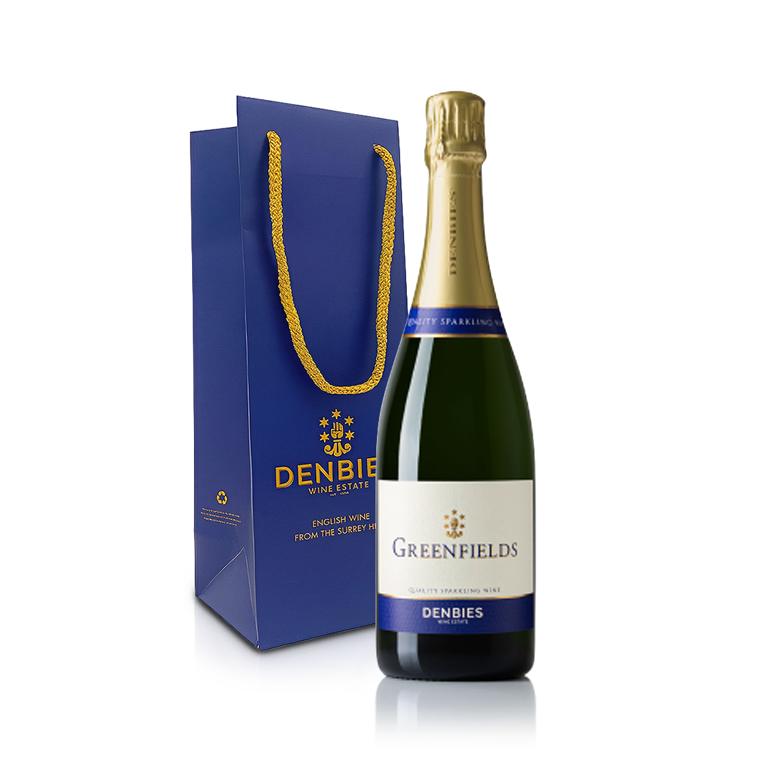 Front view of Greenfields sparkling wine bottle by Denbies Wine Estate and blue Denbies gift bag isolated on a transparent background