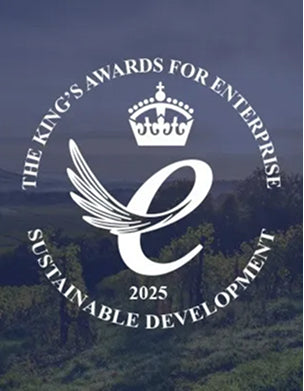 King's Awards for Enterprise Sustainable Development 2025 logo with a crown and wings against a blurred natural background.