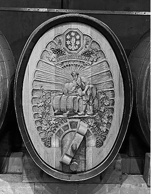 Decorative wooden panel with intricate carvings and a central figure, likely from a historical or cultural artifact.